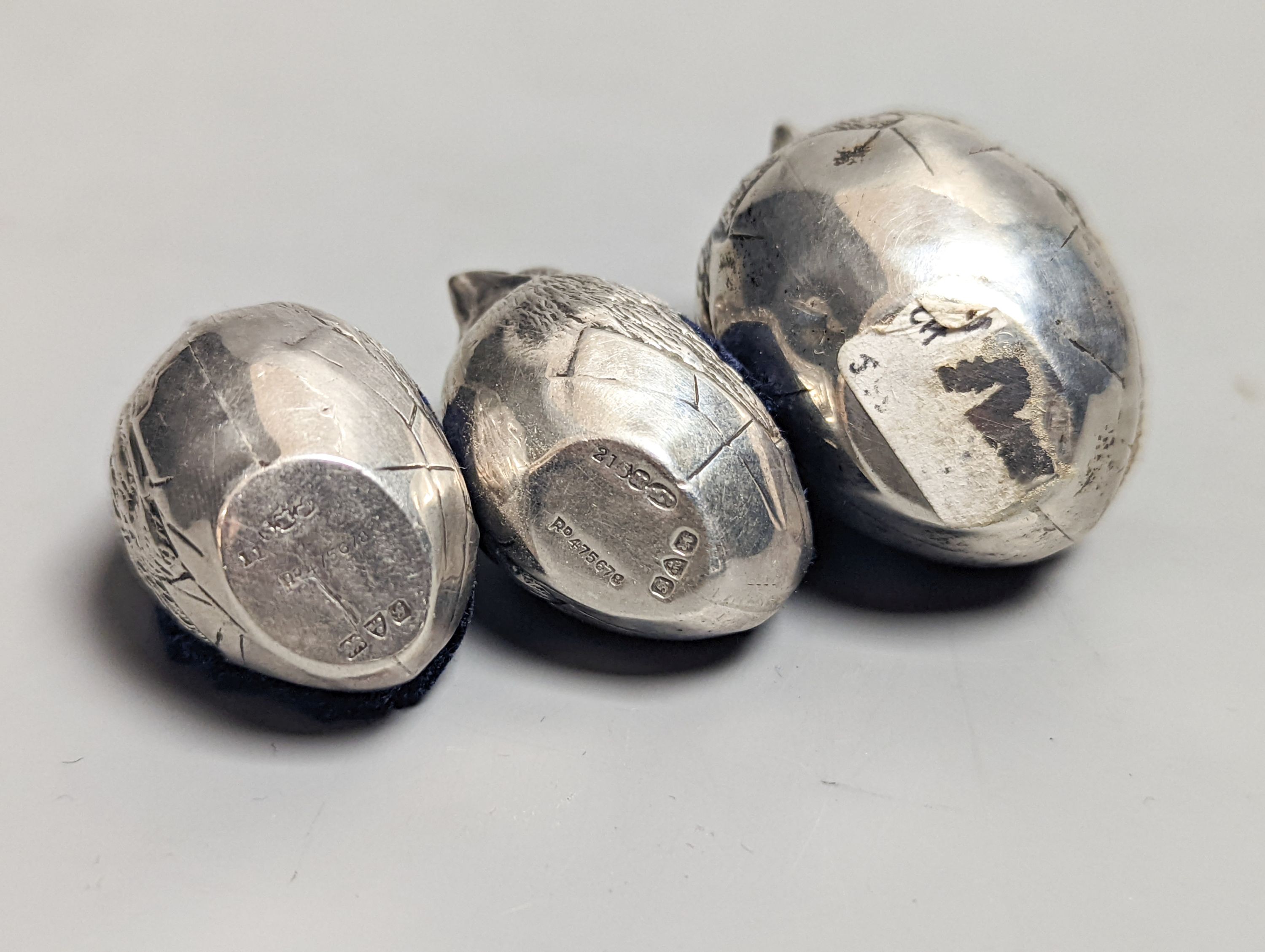 A suite of three Edwardian novelty silver mounted chick pin cushions, by Sampson Mordan & Co, Chester, 1907, height 43mm(1) & 33mm(2).
